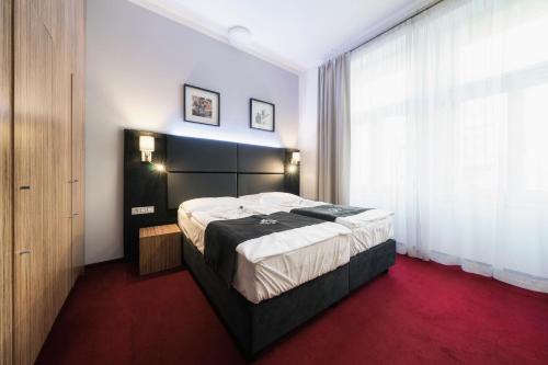 a bedroom with a large bed and a large window at Hotel NOIR in Prague