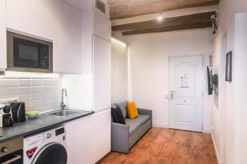 a kitchen with a sink and a couch in a room at Vibe Apartments by Olala Homes in Hospitalet de Llobregat