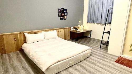 a large white bed in a room with a table at Qilin Valley in Puli