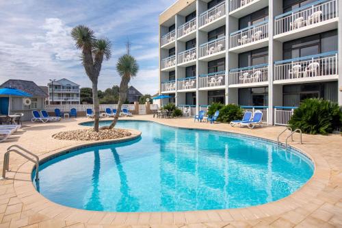 a swimming pool in front of a hotel at Travelodge by Wyndham Outer Banks/Kill Devil Hills in Kill Devil Hills