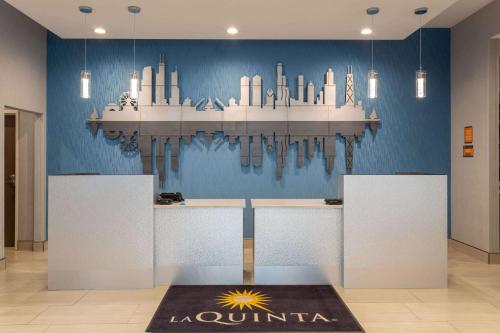 a chandelier hanging from a blue wall in a room at La Quinta Inn & Suites by Wyndham Shorewood in Shorewood