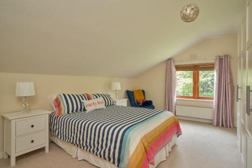 a bedroom with a bed with a striped comforter and a window at Dublin 'Home from Home', Luxury, Private Secure House in Dublin