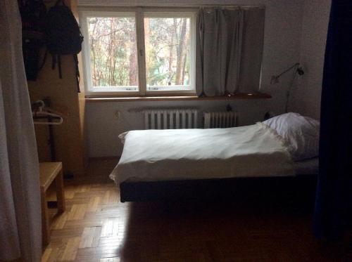 a small bedroom with a bed and a window at Pokój w domu z ogrodem w Milanówku in Milanówek