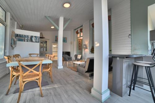 une salle à manger et un salon avec une table et des chaises dans l'établissement Gite 8 personnes - La Ronçoise, à Ronce-les-Bains