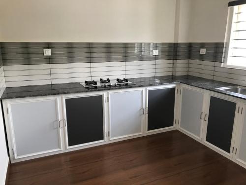 a kitchen with white cabinets and a counter top at Royal residency in Tindummal