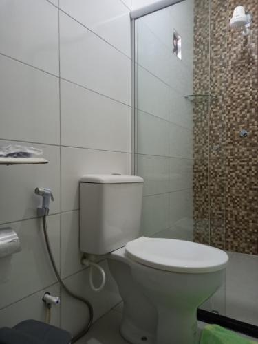 a white toilet in a bathroom with a shower at Propriedade patolo in São Miguel dos Milagres