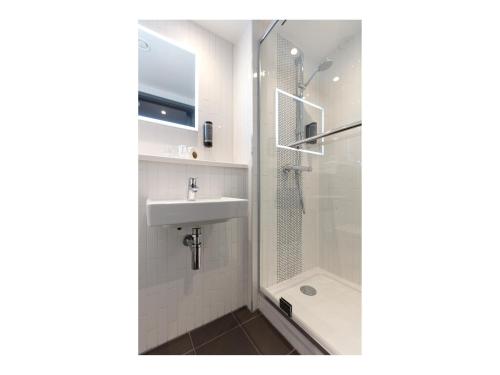 a bathroom with a shower and a sink at Point A Hotel Dublin Parnell Street in Dublin