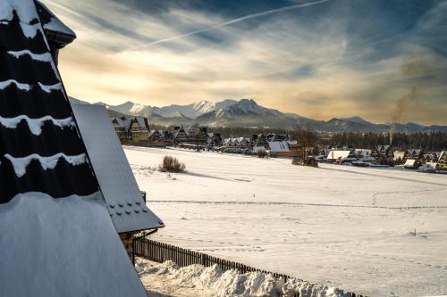 a view of a snow covered field with mountains at Willa w Ubocy - "Jacuzzi i Sauna w ofercie dodatkowo płatnej" in Murzasichle