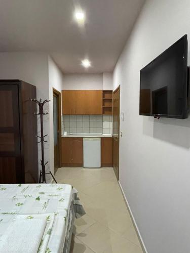 a room with a bed and a television on a wall at Vila Vadeha in Pogradec