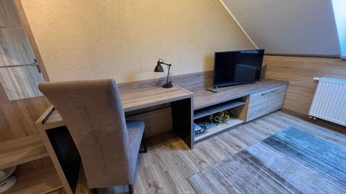 a desk with a television and a chair in a room at FitnessFun in Krzyż