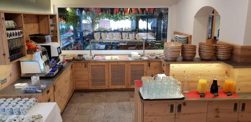 a large kitchen with wooden cabinets and a large window at Gasthaus - Pension Kärntnerhof in Faak am See