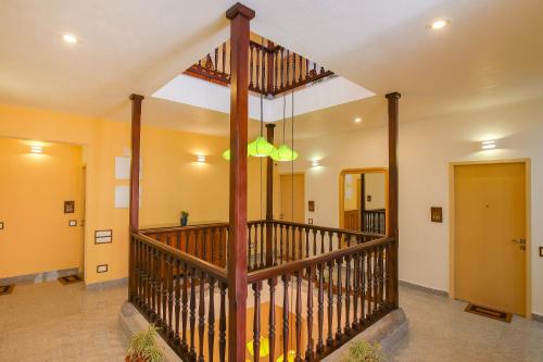 eine Largeoyer mit einer hölzernen Wendeltreppe in einem Haus in der Unterkunft AURA HOTEL in Puducherry