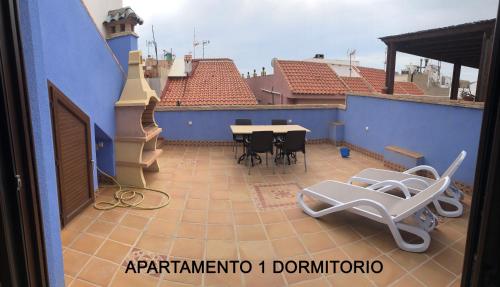 einen Balkon mit einem Tisch und Stühlen in einem blauen Gebäude in der Unterkunft MARIAGUERRERO - La Casita Azul in Cabo de Palos