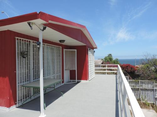 a red building with a ramp leading to a porch at TONGOY CASA INTIMA Y FAMILIAR in Coquimbo