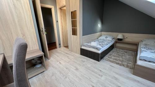 a small room with two beds and a chair at FitnessFun in Krzyż