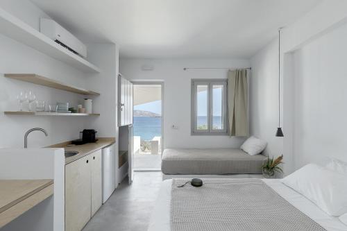 a white room with a bed and a window at Teal Blue in Koufonisia