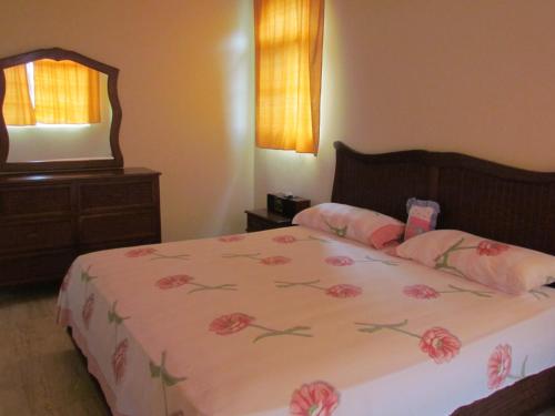 a bedroom with a bed and a dresser and a mirror at Villa Sosua Hispaniola Residencial in Sosúa