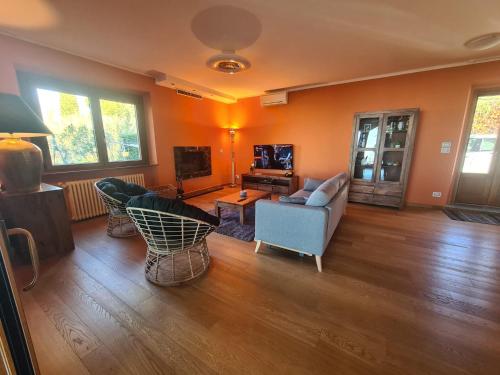 a living room with a couch and chairs and a tv at Casa dei Tramonti in San Feliciano