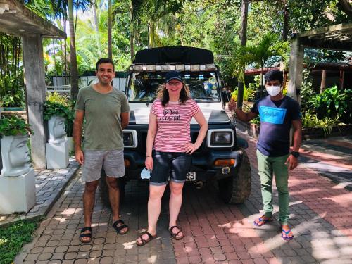 a group of three people standing in front of a car at Tishan Holiday Resort in Polonnaruwa
