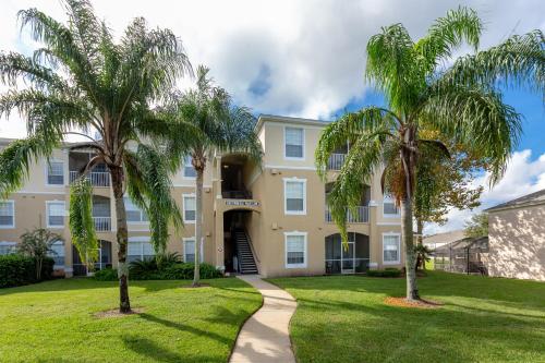 una casa con palmeras delante en The Great Escape - A spacious 1st floor condo on Windsor Palms Resort - close to Disney, en Kissimmee