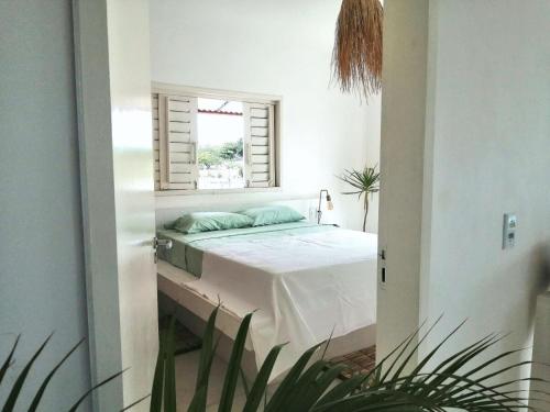 1 dormitorio con cama y ventana. en La Mangrove - Casa com piscina na Praia do Preá, en Prea