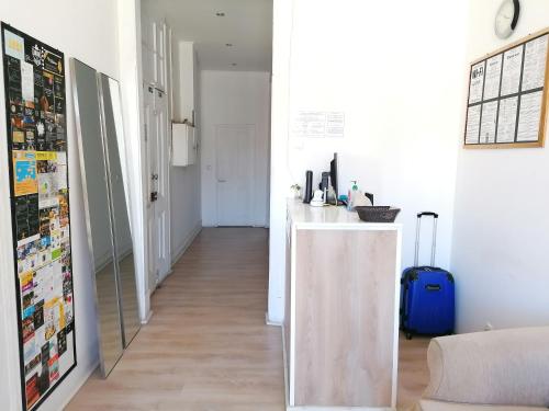 a hallway with a white counter and a blue suitcase at Chiado Open World Hostel in Lisbon