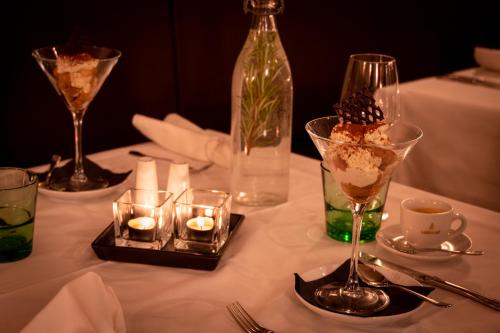 a table with candles and wine glasses and a bottle at Hotel Auwirt Zentrum in Saalbach Hinterglemm
