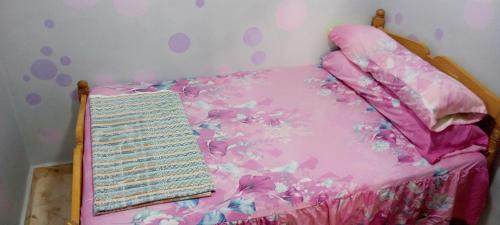 ein Schlafzimmer mit einem rosa Bett mit einer rosa Tagesdecke in der Unterkunft house for girls in Alexandria