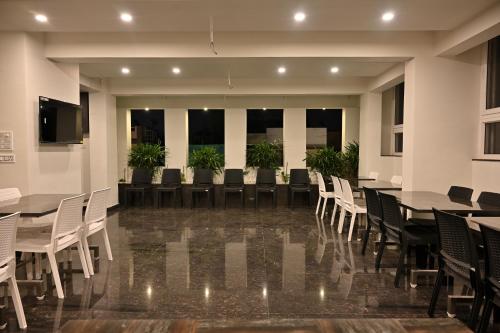 una sala de conferencias con mesas, sillas y plantas en Mysore Royale, en Mysore