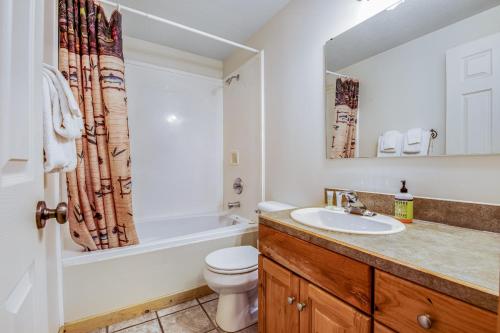 a bathroom with a sink and a toilet and a tub at Worthen Cabin in Garden City