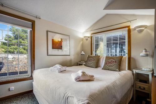 Beaches Inn | Herons Nest Loft في كانون بيتش: غرفة نوم بسرير كبير عليها منشفتين
