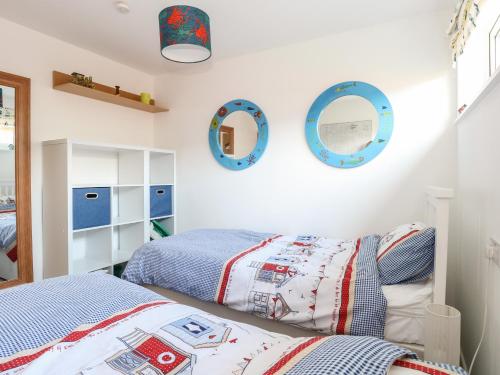 a bedroom with two beds and mirrors on the wall at 31 Seaward Crest in Norwich