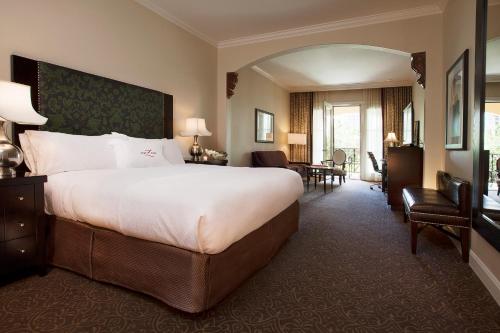 a bedroom with a large bed and a living room at Hotel ZaZa Dallas in Dallas