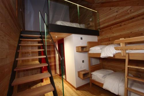 a room with four bunk beds and a staircase at Pra de la Casa in Madonna di Campiglio