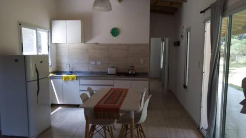 a kitchen with a table and chairs and a refrigerator at La Paloma Chapadmalal in Mar del Plata