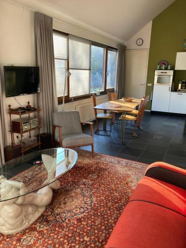 a living room with a red couch and a table at Nieuw Kagelink in Diepenheim