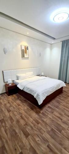 a bedroom with a large bed and a wooden floor at HAVANA HOLIDAY HOMES MIRDIF in Dubai