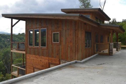 a small house with a roof on a lot at The Overlook - '21 Cabin - Gorgeous Unobstructed Views - Fire Pit Table - GameRm - HotTub - Xbox - Lots of Bears in Gatlinburg