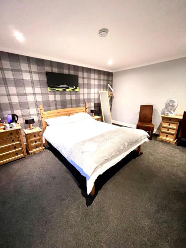 a bedroom with a large bed and a chair at MacArthur House NC500 in Wick