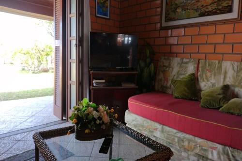 a living room with a couch and a tv at Casa da Felicidade in Tramandaí