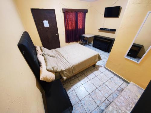 Dormitorio pequeño con cama y TV en Hotel Diaz 