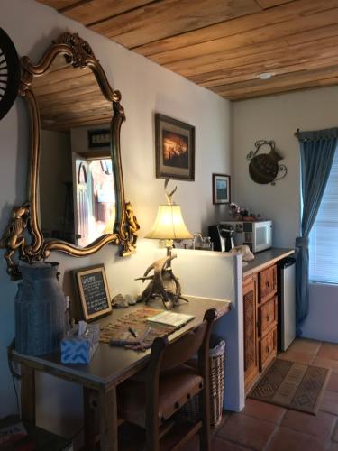 a room with a desk and a mirror on the wall at Spur Cross Inn in Cave Creek