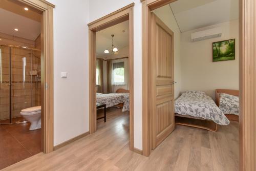 a room with a toilet and a bathroom with two beds at Vila Trakai in Trakai