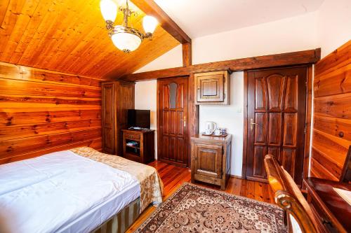 a bedroom with a bed and a wooden wall at Hotel Dworek Wapionka in Górzno