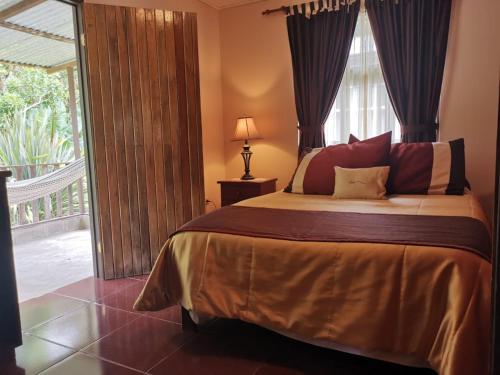 a bedroom with a bed and a large window at Cabinas El Quetzal in San Gerardo de Dota