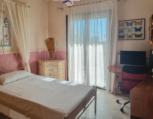 a bedroom with a bed and a desk and a window at Spacious House in a Quiet Neighbourhood in Ierapetra