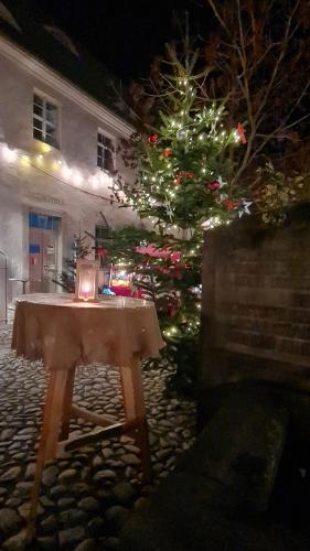 a table with a christmas tree in front of a building at Hotel Cranach-Herberge City Centre in Lutherstadt Wittenberg
