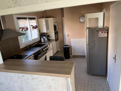 a kitchen with a refrigerator in the middle of it at Maison 4 chambres cusset in Cusset