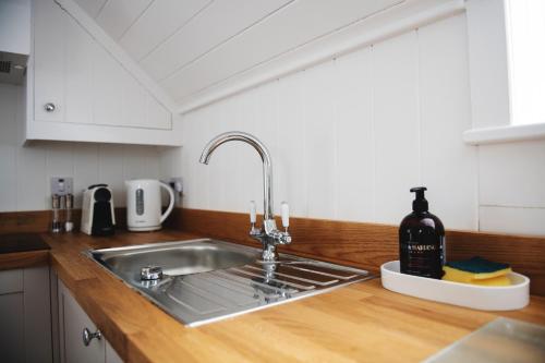 a kitchen counter with a sink and a bottle of wine at Central Location - Riverside - Cosey Cottage - Close to Beaches in Christchurch