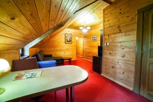 a room with wood paneling and a staircase in a cabin at Hotel Dworek Wapionka in Górzno